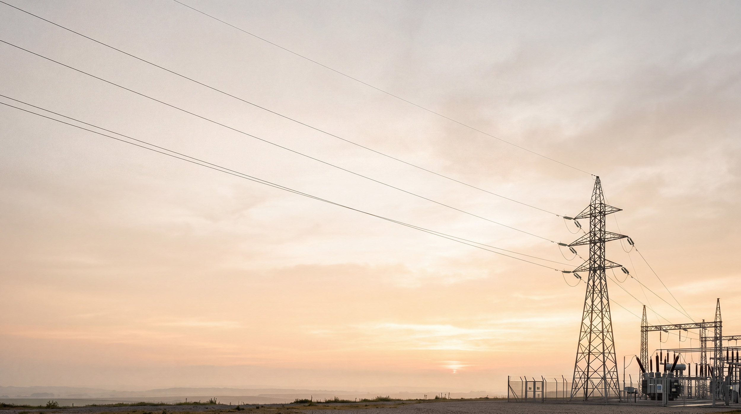 Transmission tower and substation at sunset
