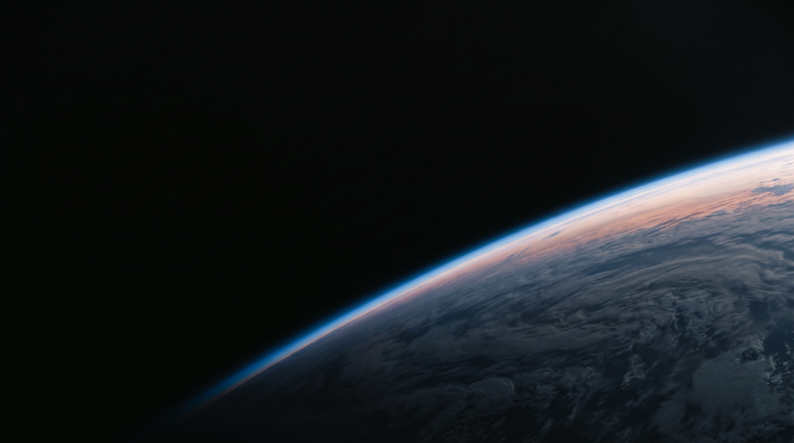 Earth's curved limb seen from orbit against black space