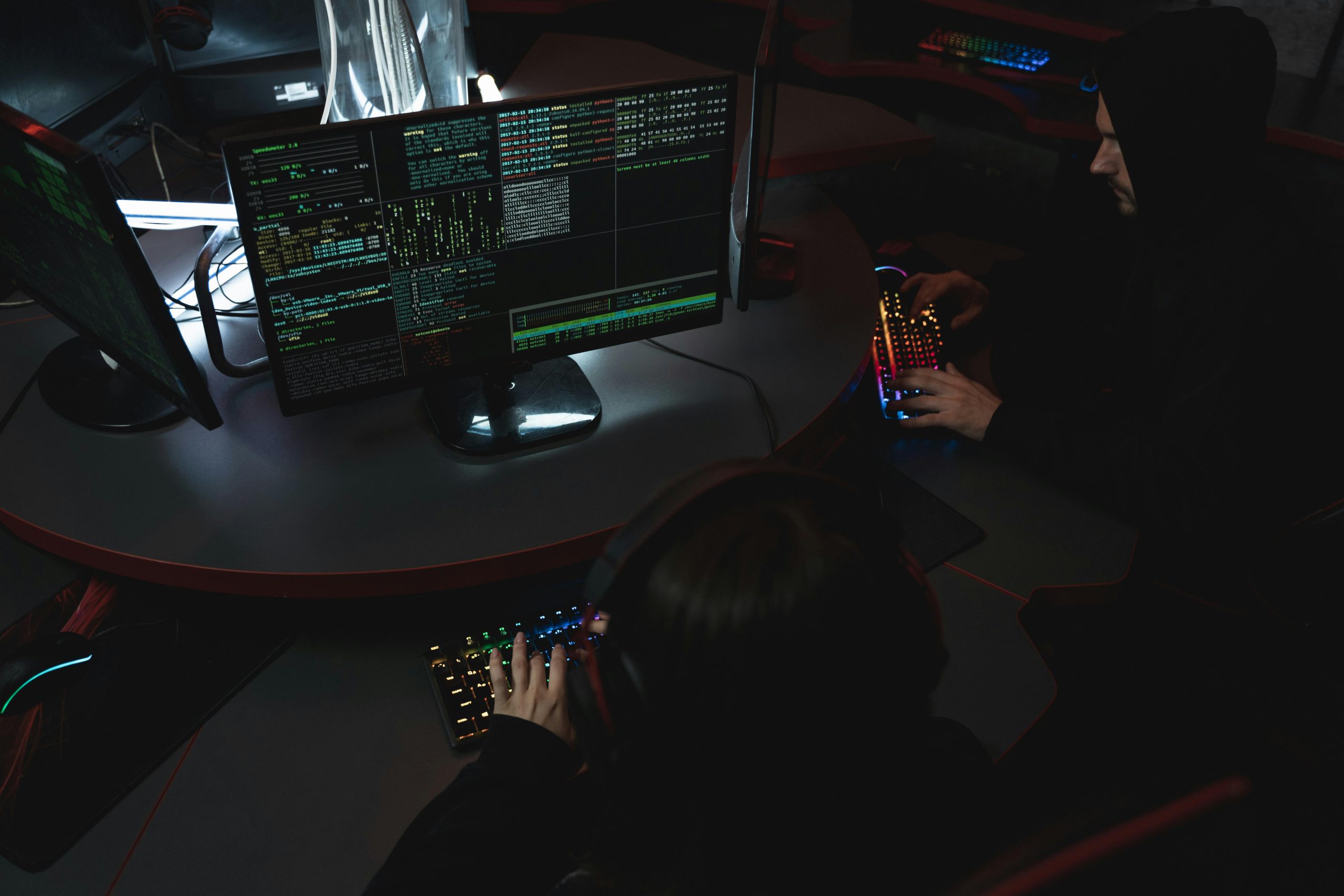 Two operators working at multi-monitor terminals in a darkened room